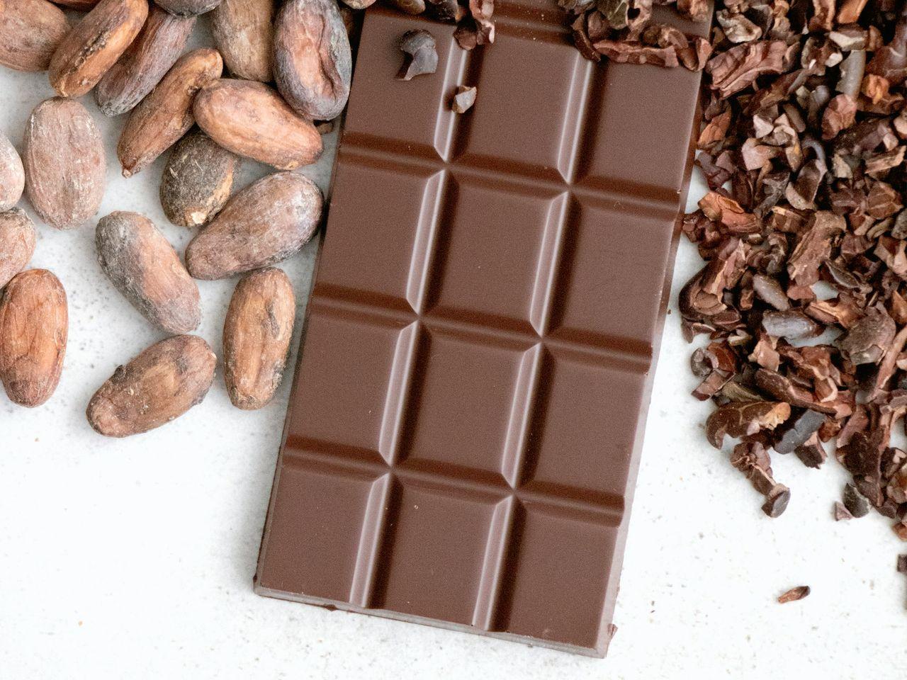 a bar of chocolate next to a pile of nuts