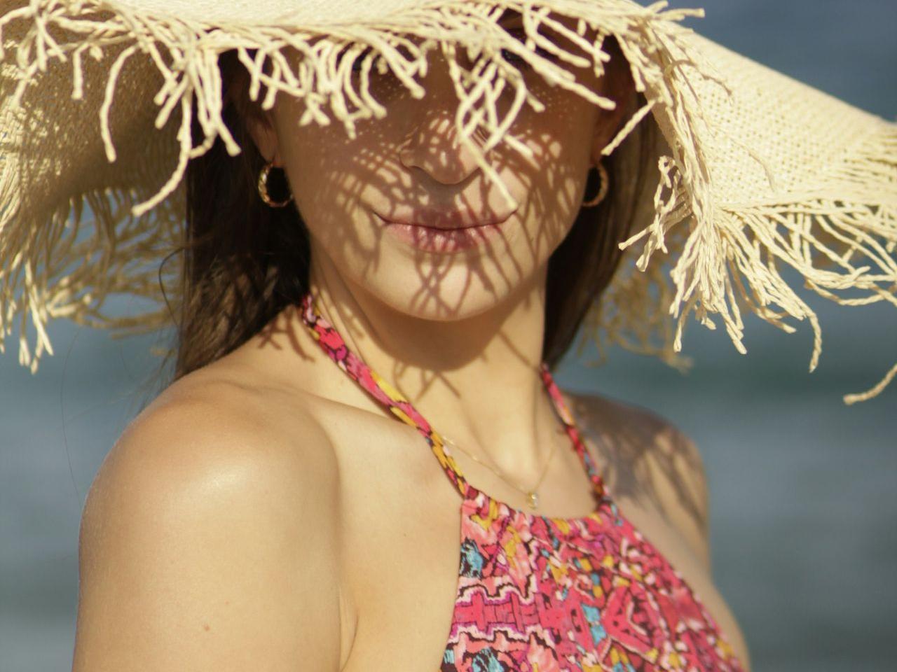 woman in red and white floral bikini top wearing brown straw hat