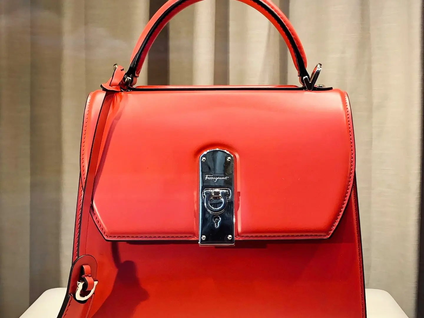 red leather handbag on white table