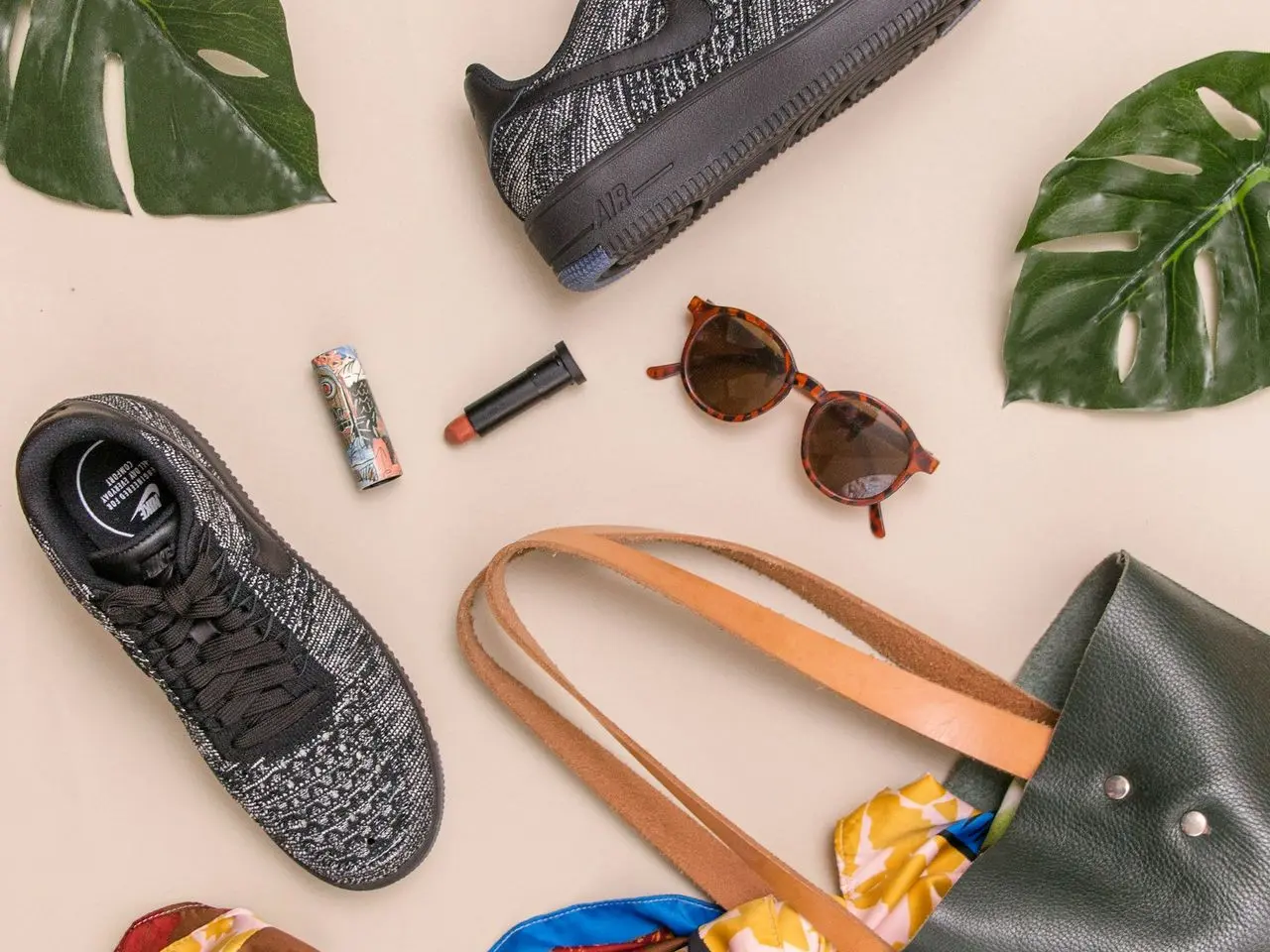 photo of bag, sneakers, and sunglasses on beige surface