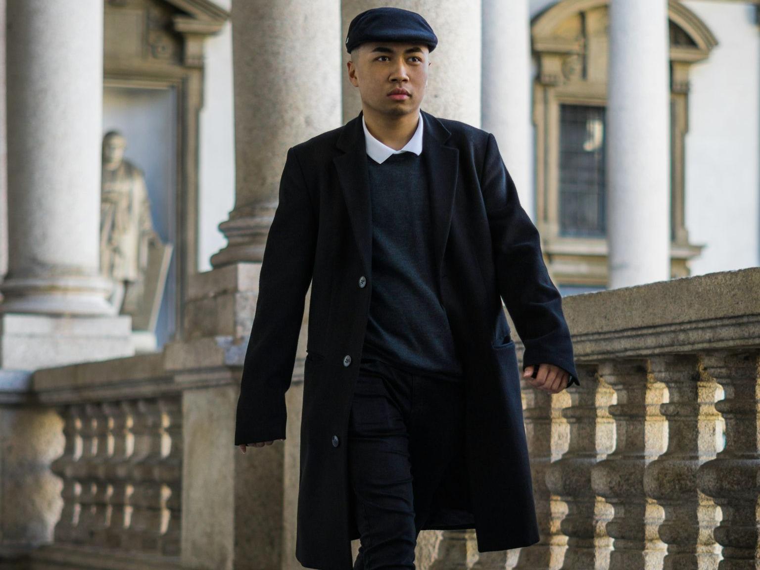 man in black coat walking on sidewalk during daytime