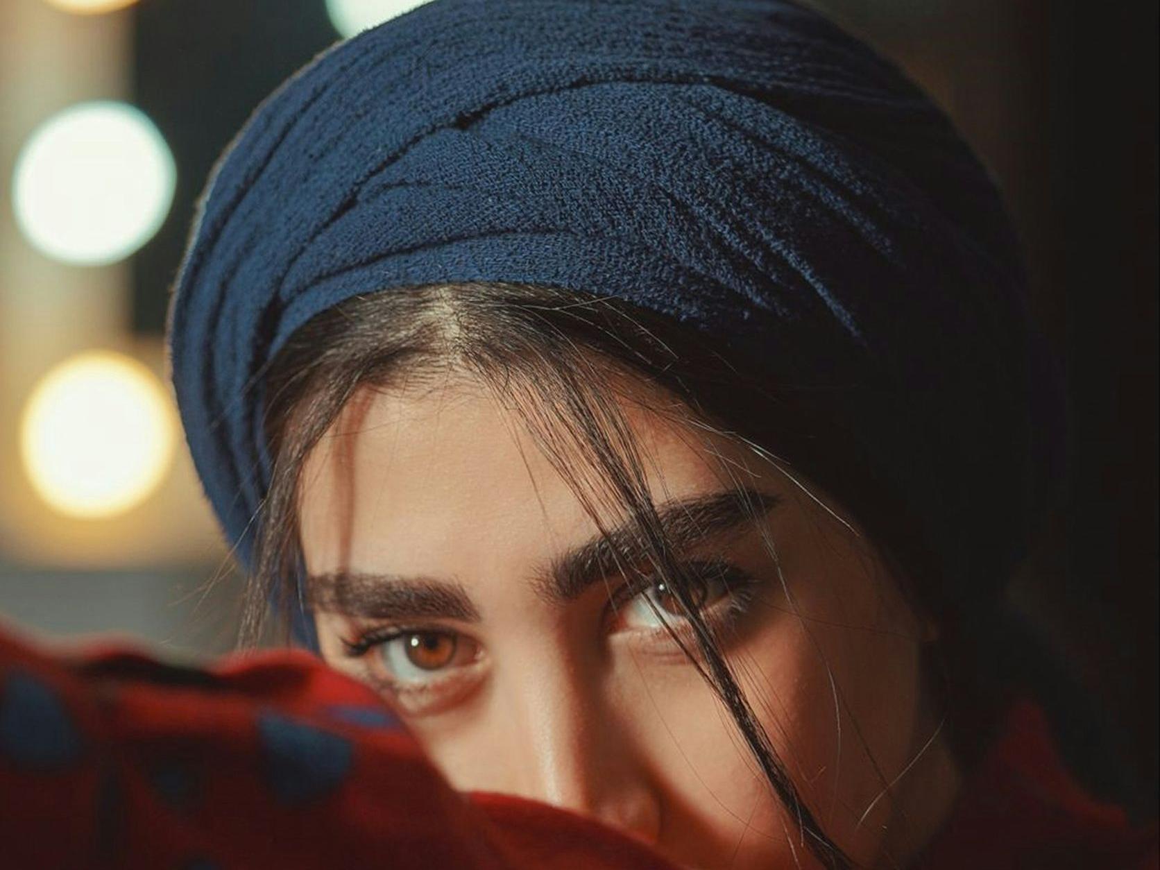 woman in red scarf wearing black knit cap